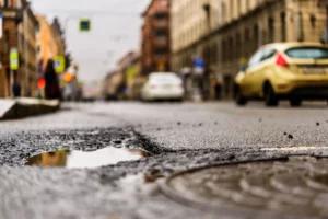 immagine di una buca sulla strada. per la manutenzione della strada verrà usato asfalto a freddo